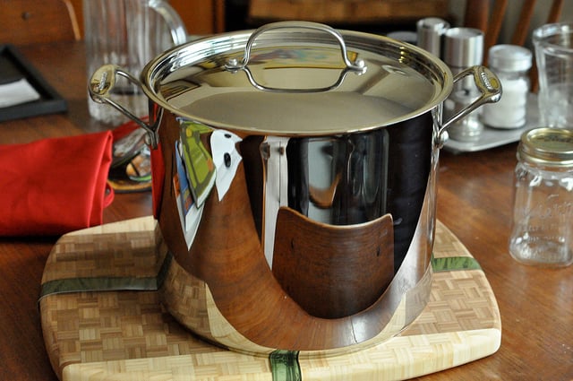 Large big pot of homemade vegetable soup and granite counter top in kitchen  in stainless steel container on gas stove cooking and nobody Stock Photo