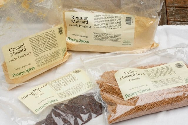 Various packages of mustard seeds and powders. 