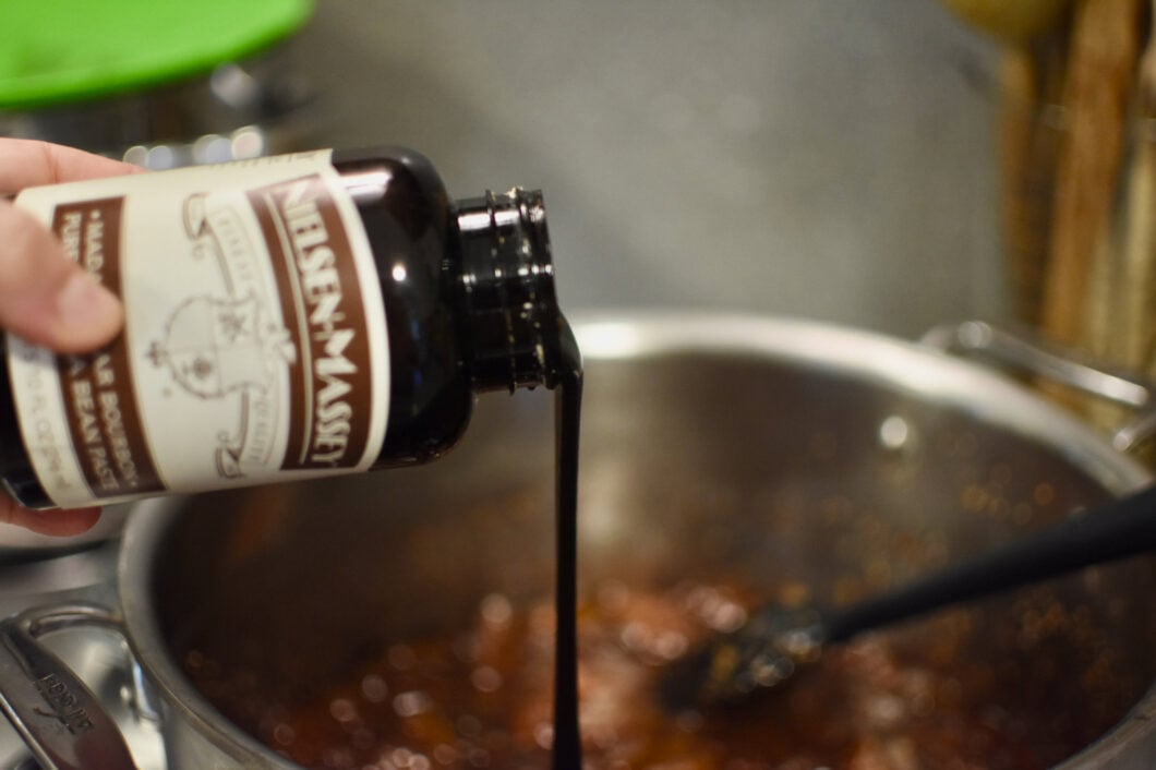 Adding approximately 1 tablespoon of vanilla bean paste to fig jam.