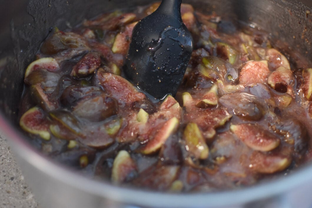 Stirring the figs and sugar together in a large pot.